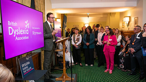 Adam Dance MP speaks at a British Dyslexia Association event in Parliament, addressing a room full of attendees gathered to support greater awareness and action on dyslexia.