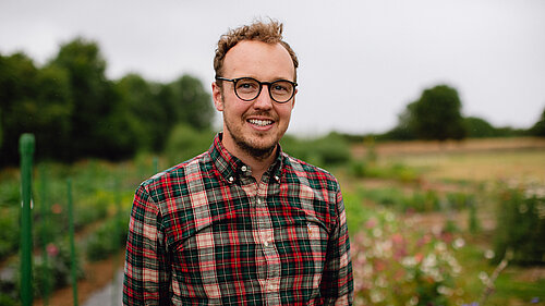 Adam standing in a field